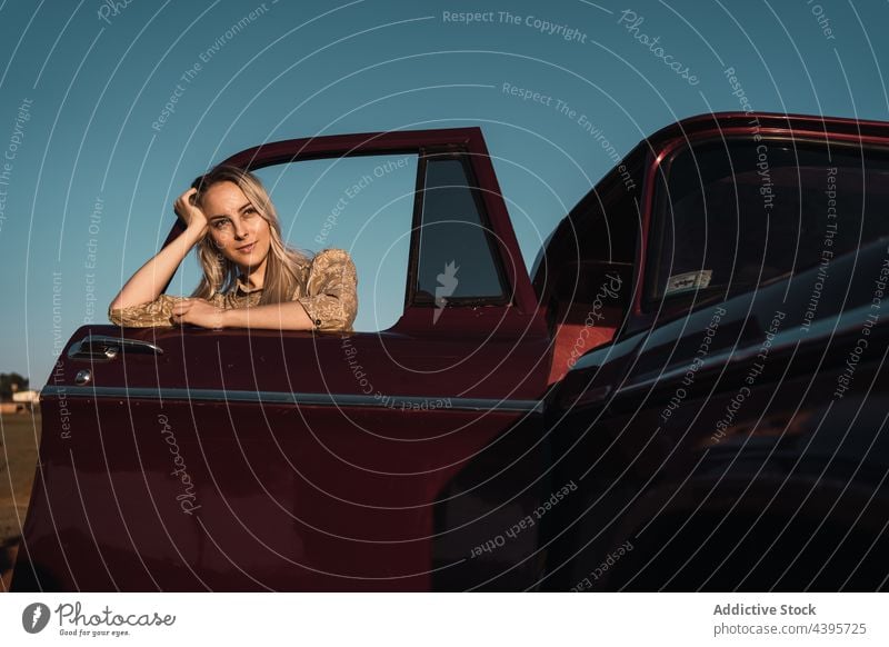 Carefree woman sticking out of car window stick out carefree freedom enjoy summer cheerful happy female nature evening vehicle sunset sunlight blue sky