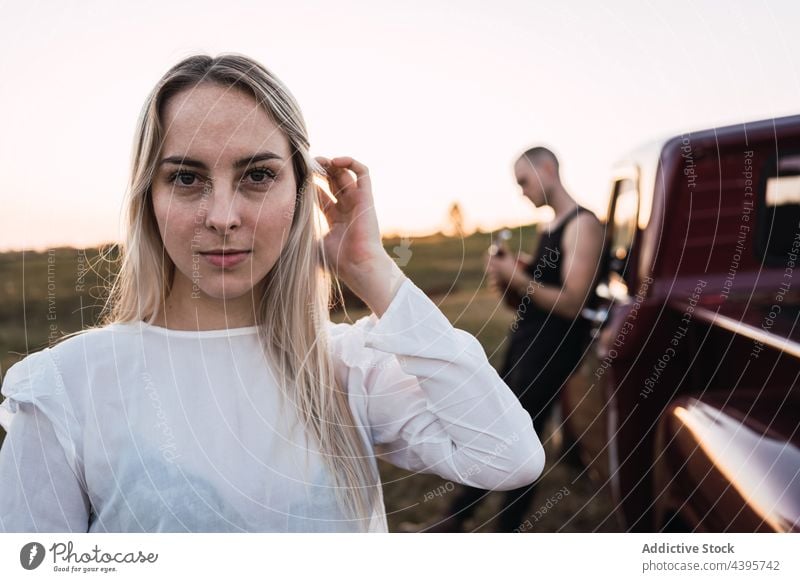 Serene woman standing near retro car against man serene sunset countryside couple vintage portrait together old fashioned female vehicle human face style