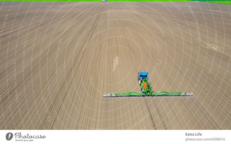 Aerial view on tractor as spraying field with sprayer, herbicide and pesticide Above Aerosol Agricultural Agriculture Arable Biochemical Biohazard Care Cereal