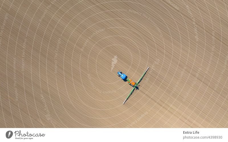 Aerial view on tractor as spraying field with sprayer, herbicide and pesticide Above Aerosol Agricultural Agriculture Arable Biochemical Biohazard Care Cereal