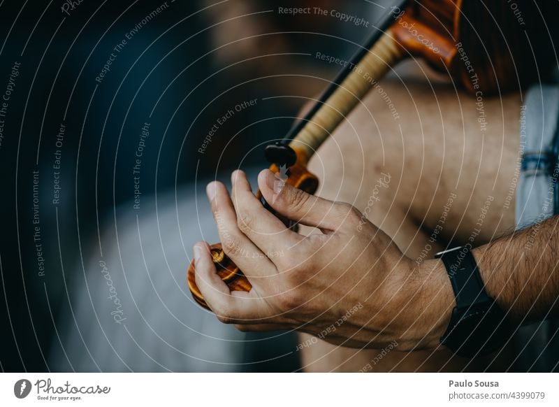 Close up man tuning violin Violin Violinist String instrument Musician Wood Musical instrument string Listen to music Make music Interior shot Orchestra