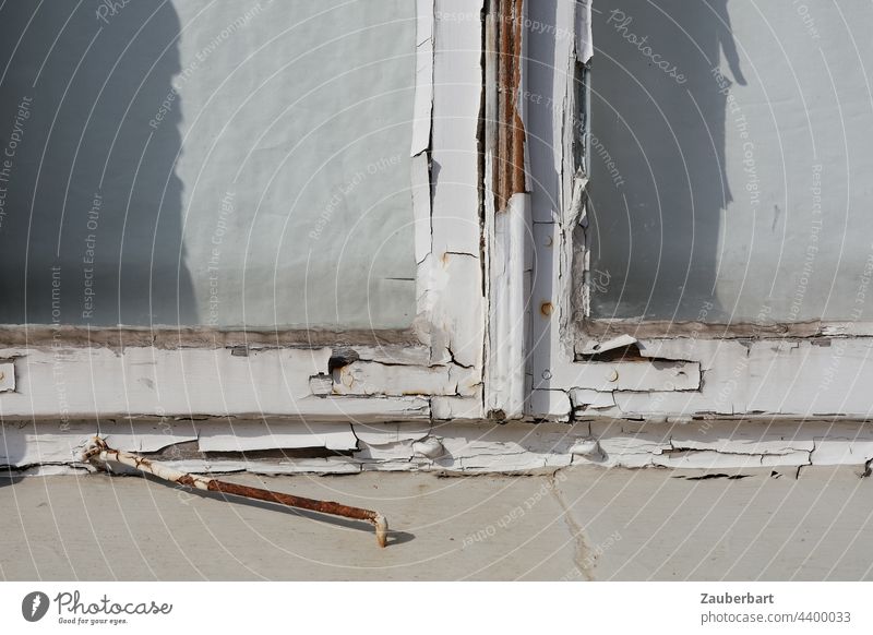 Old window frame with peeling white paint and a discarded hook on a vacant house Window frame Flake off Colour Checkmark filing White