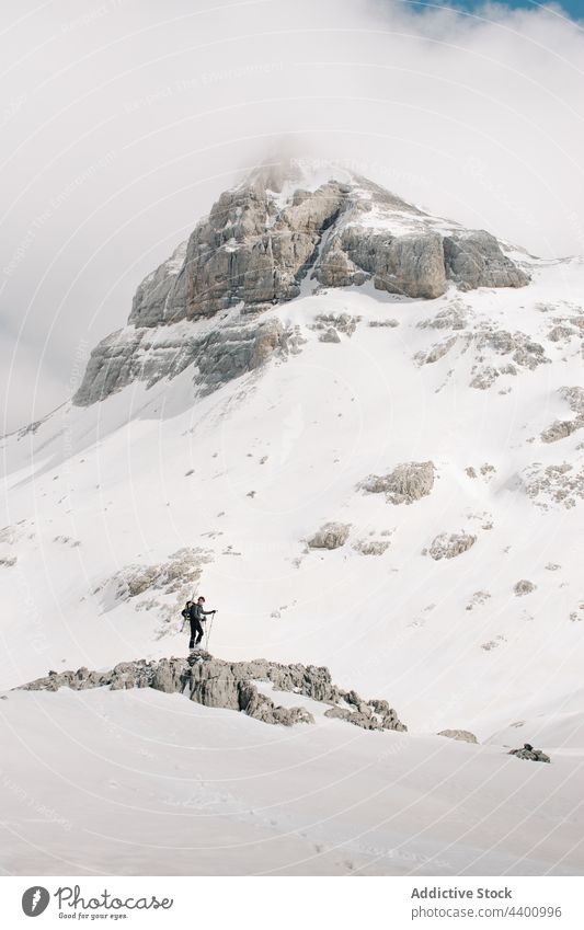 Unrecognizable skier on rough mount with snow in winter mountain pyrenees sport cloudy sky nature highland recreation athlete atmosphere air ridge weekend