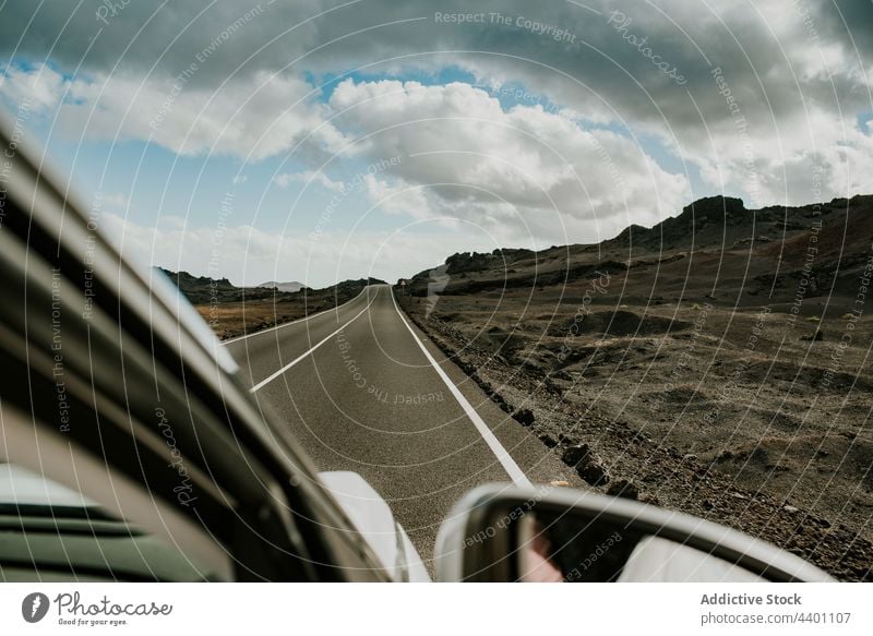 Car driving through countryside on cloudy day car drive road travel sky rock explore weekend volcanic spain canary islands road trip transport vehicle nature