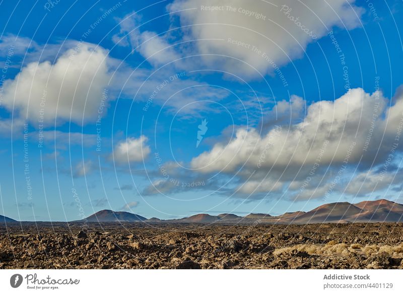 Cloudy sky over rocky valley hill blue sky cloudy stone volcanic summer nature ground terrain landscape fuerteventura spain canary islands mountain environment