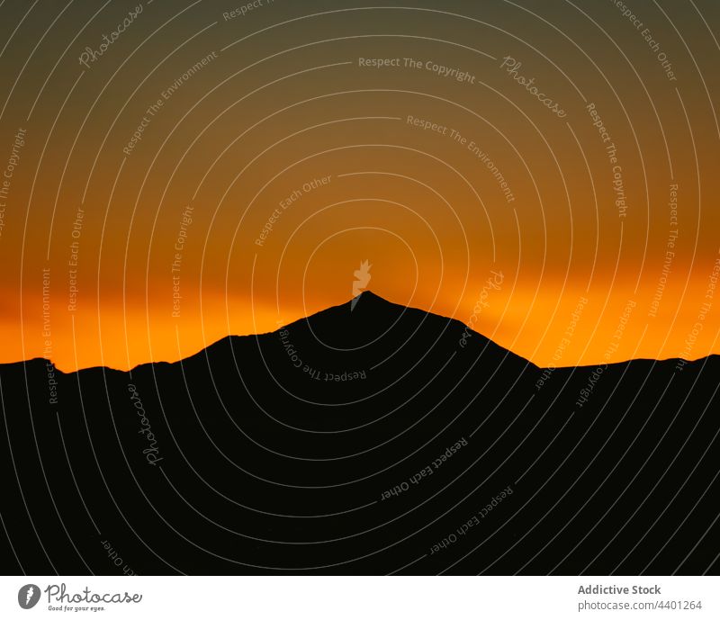 Amazing sunset over silhouette of mountains orange sky highland sundown evening landscape bright nature vivid vibrant dusk dark ridge picturesque twilight