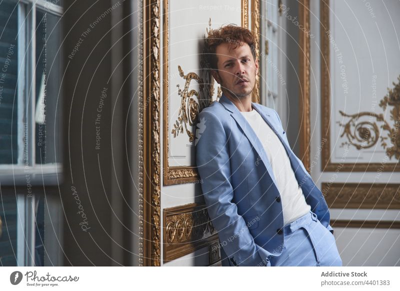 Pensive man in suit in luxury room thoughtful sad pensive male style lean wall guy rich posh stand appearance concern well dressed mood indoors trendy handsome