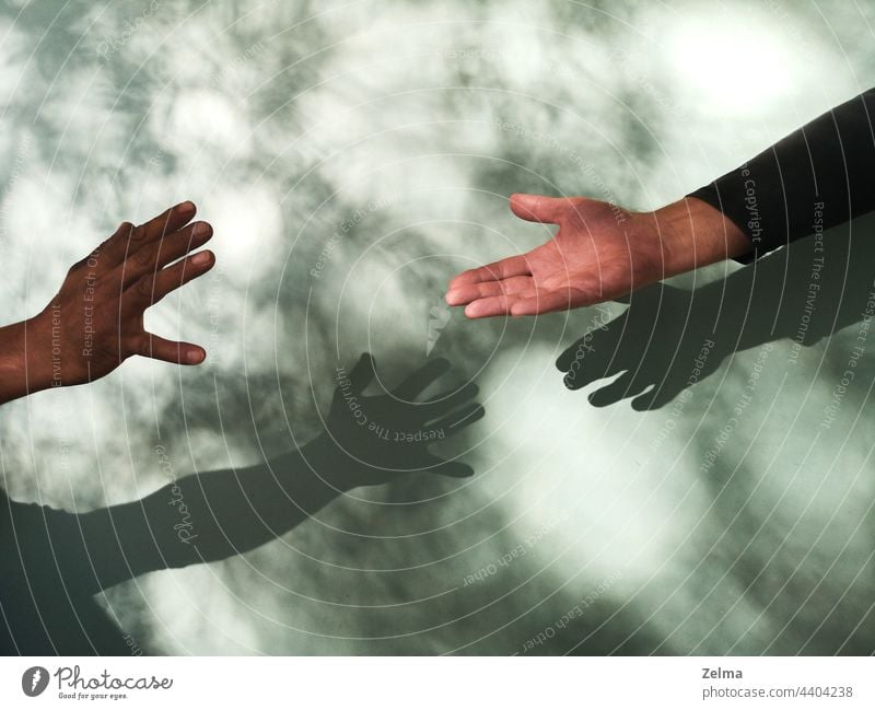 Helping hand with shadows on monochrome background.Concept of human relation, community, togetherness, symbolism, culture and history help two woman healing