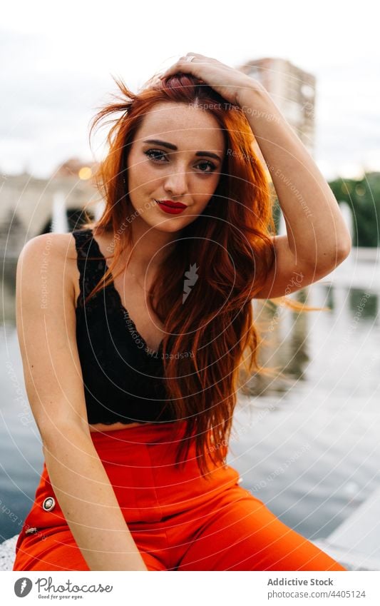 Trendy redhead woman on embankment in city style trendy pants orange bright color female vivid vibrant positive happy smile cheerful urban enjoy carefree