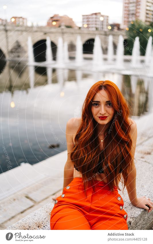 Trendy redhead woman on embankment in city style trendy pants orange bright color female vivid vibrant positive happy smile cheerful urban enjoy carefree