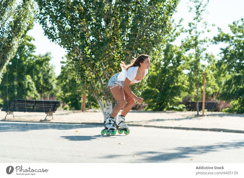 Woman in rollerblades and showing stunt woman trick equilibrium skater summer wheel street female activity practice sunny sunlight summertime road fit urban