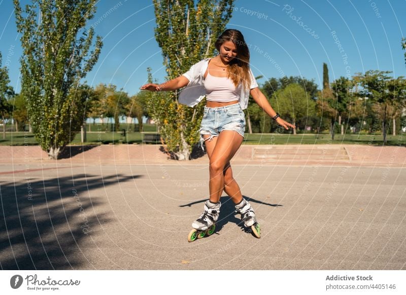 Woman in rollerblades and showing stunt woman trick equilibrium skater summer wheel street female activity practice sunny sunlight summertime road fit urban