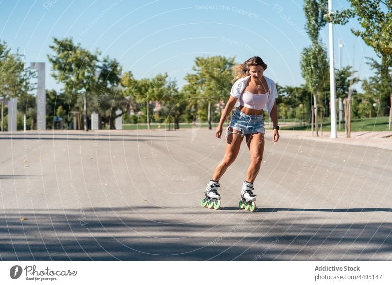 Woman in rollerblades and showing stunt woman trick equilibrium skater summer wheel street female activity practice sunny sunlight summertime road fit urban