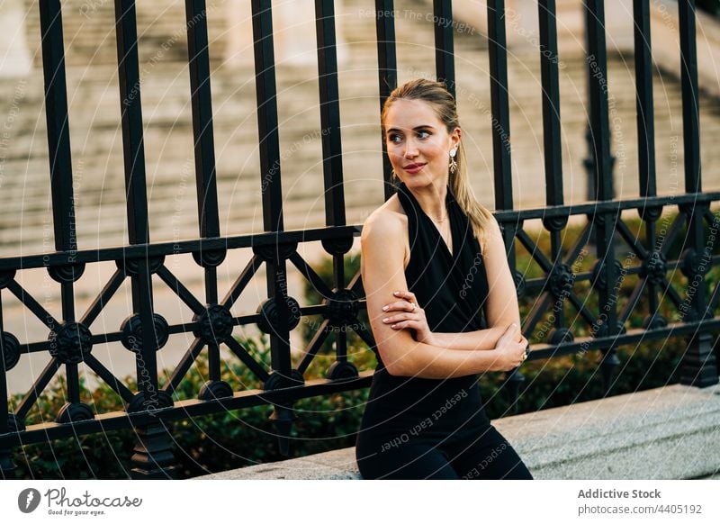 Smiling elegant woman in city street grace outfit smile style trendy content female arms folded urban happy sit bench charming fashion joy glad positive