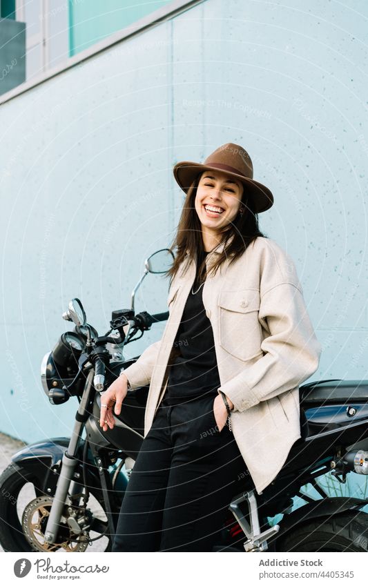 Female motorcyclist near motorbike parked in street woman biker rider motorcycle determine female cool confident self assured self confident road roadway