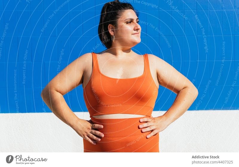 Plus size ethnic sportswoman with hands on waist athlete hand on waist healthy lifestyle vitality wellness self assured plump street energy overweight confident