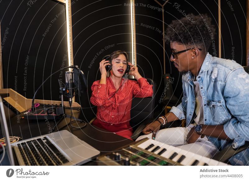 Multiracial colleagues recording music in studio musician together microphone song sing singer multiracial multiethnic diverse black african american sound