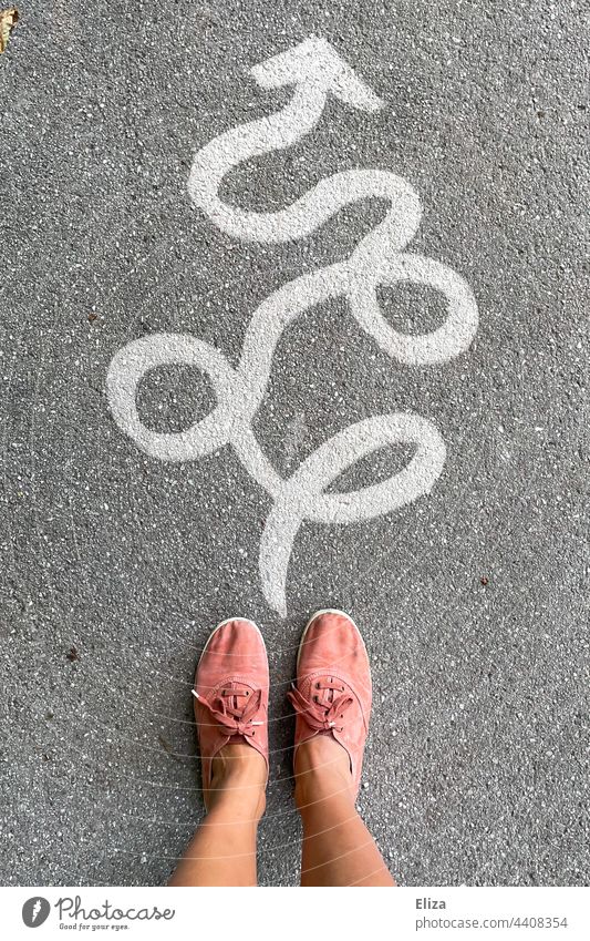 Person stands in front of a winding arrow to the front - via detours to the goal Detour Arrow twisted Forwards off Orientation Future Success Detours person