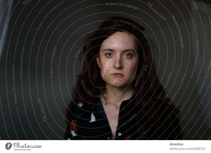 Portrait of a young woman in a dark room Woman Young woman Brunette long hairs Long-haired pretty Direct artist portrait Artificial light Wall (building)