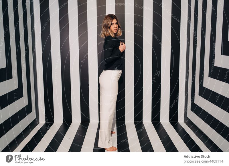 Sensual model in stylish jacket on striped background fashion style sensual seductive trousers contrast woman portrait breast pants provocative trendy black