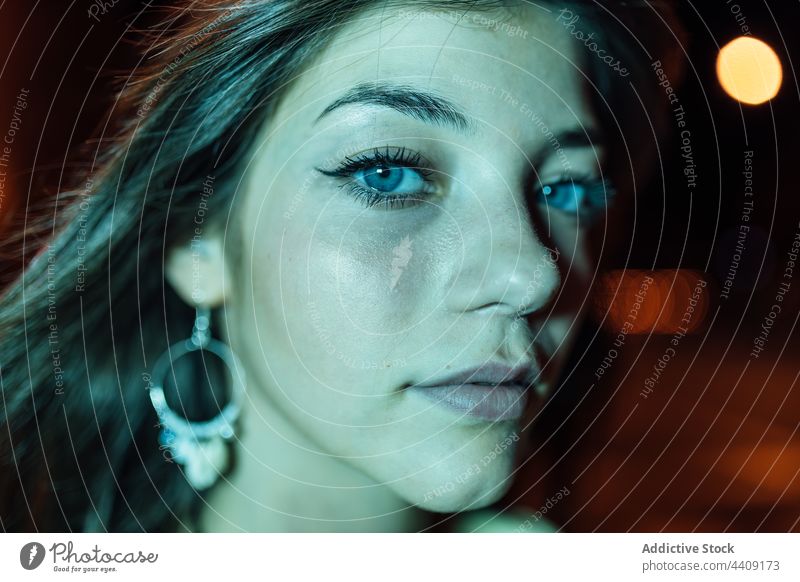 Sincere woman on urban pavement at night sincere friendly charming kind enjoy road city portrait town pleasant dusk roadway streetlight evening colorful stare