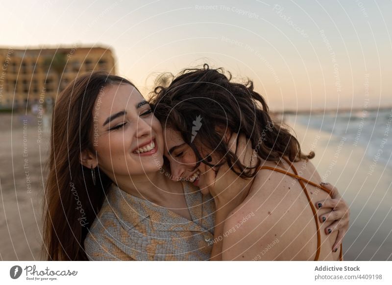 Happy lesbian couple embracing on beach women sea sundown hug love date female girlfriend romantic together sunset coast embrace relationship vacation summer