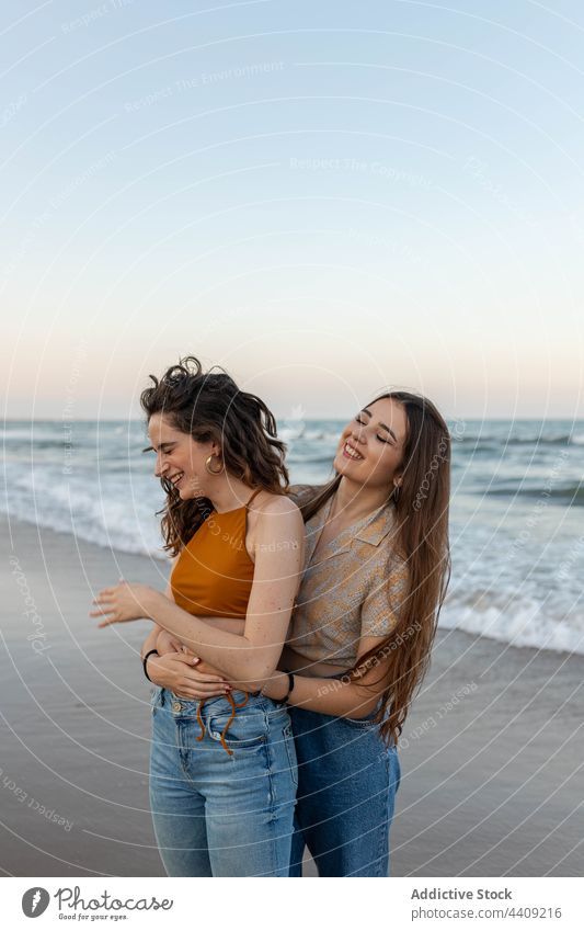 Happy lesbian couple embracing on beach women sea sundown hug love date female girlfriend romantic together sunset coast embrace relationship vacation summer