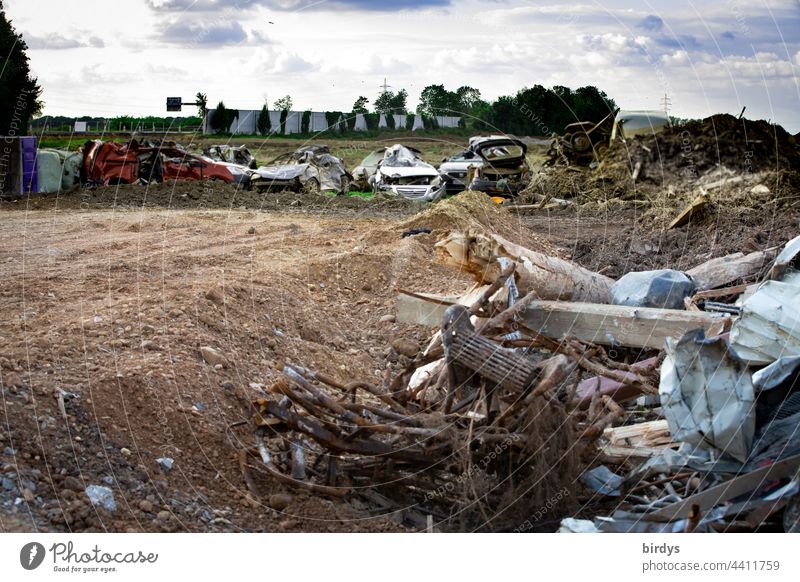 After the flood disaster in Erftstadt - Blessem, destroyed cars and rubble on the bank of the Erft, in the background the washed out A 61 with collapsed noise barriers.