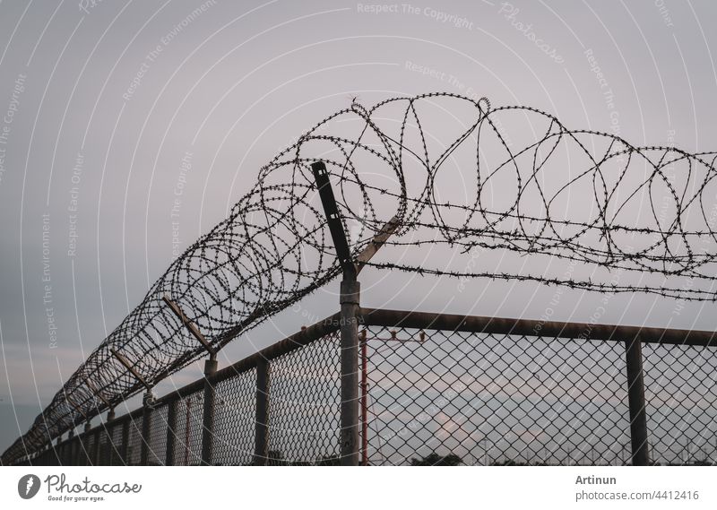 Prison security fence. Barbed wire security fence. Razor wire jail fence. Barrier border. Boundary security wall. Prison for arrest criminals or terrorists. Private area. Military zone concept.