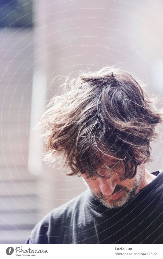 Man looks down, wind in his hair portrait Face Human being Looking Masculine kind Adults Facial hair Designer stubble Curl pretty Meditative Disheveled