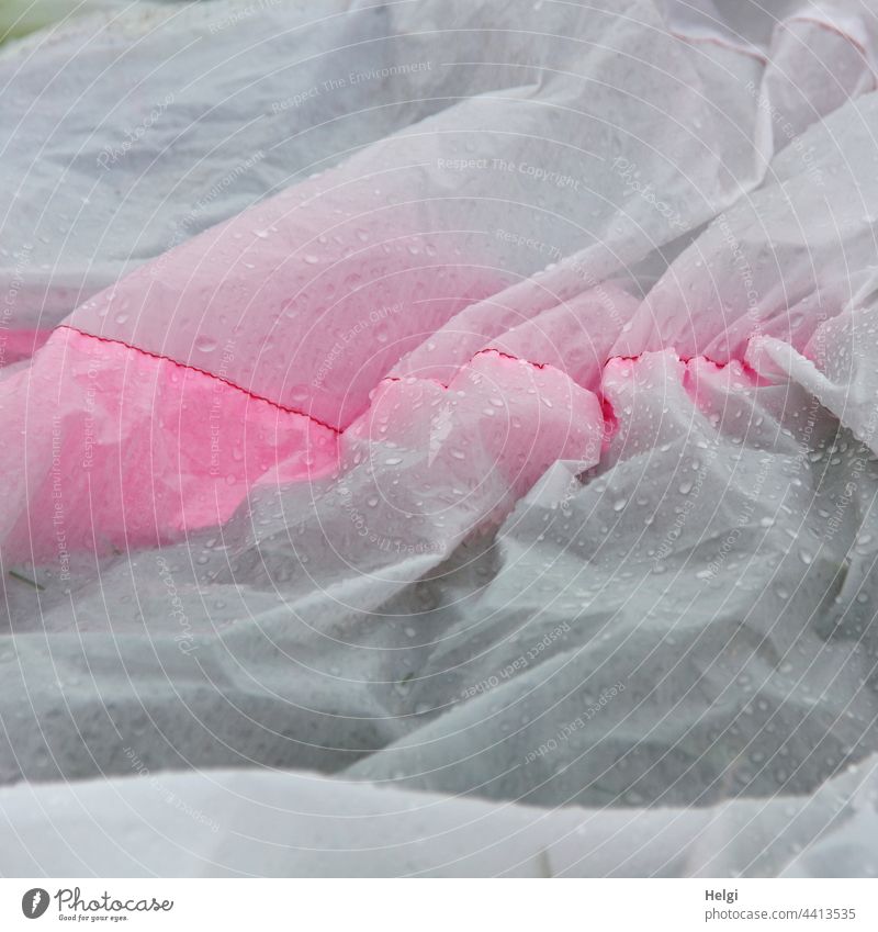 Detail of the hull of a large kite lying on the ground with raindrops kites Kite festival Sheath great dragon Cloth crease Drop Wet wrinkled out Rain