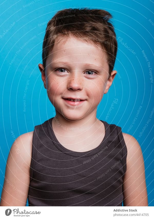 Cute child looking at camera in studio content kid boy cheerful childhood happy smile adorable cute carefree playful innocent optimist glad fun joy delight