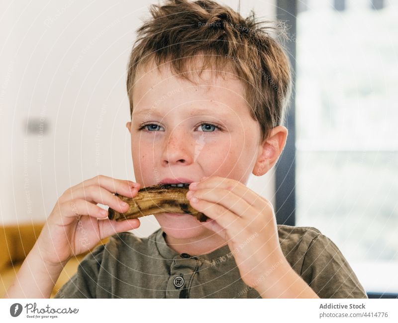 Hungry child eating pork ribs during lunch home food boy kid appetizing cute meal adorable enjoy tasty delicious nutrition domestic childhood homemade fresh