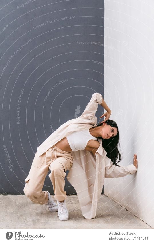 Flexible woman dancing near wall in city dance dancer perform street flexible choreography move female grace talent urban lean skill style energy hip hop