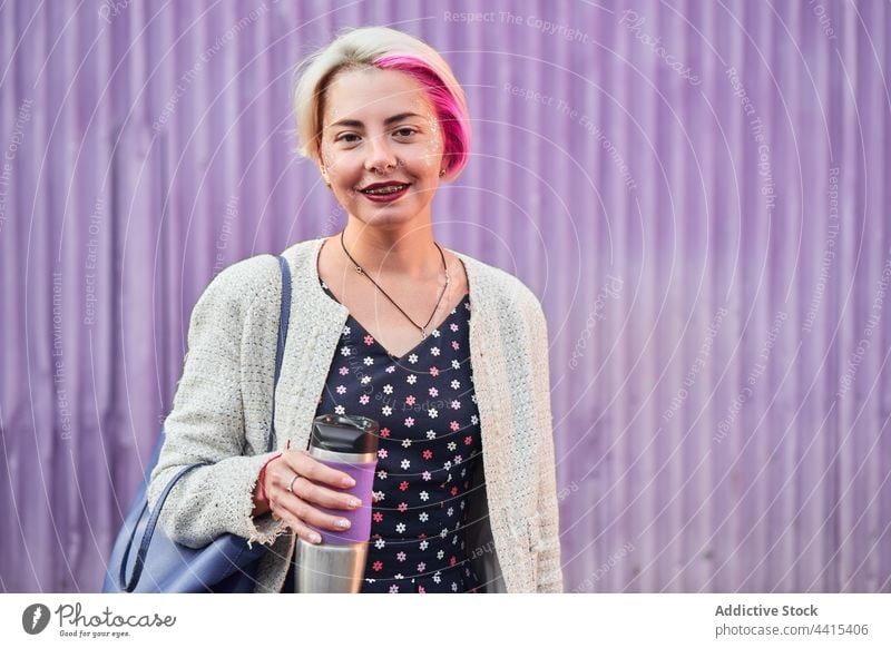 Stylish alternative woman with coffee in reusable cup style informal reuse eco friendly smile drink female city cool street subculture fancy dyed hair