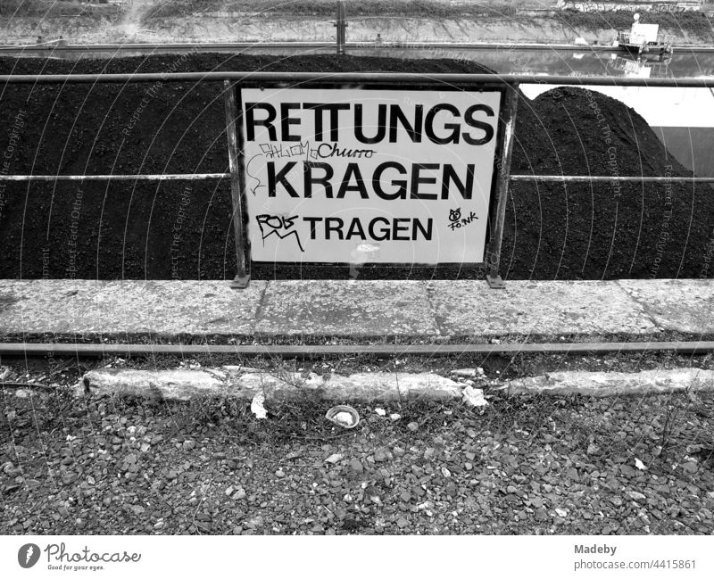 Safety notice during coal loading at the old inland port in Offenbach am Main in Hesse, photographed in neo-realistic black and white sign Warning sign