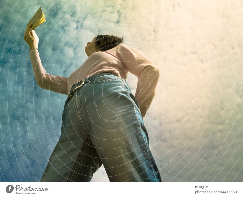 A woman holds a book up to the cloudy sky and reads Woman Reading Young woman Adults Human being Exterior shot Feminine Jeans Colour photo Leisure and hobbies