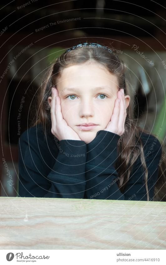 beautiful young girl, child, 10 years, in garden house, daydreaming, thoughtful, holding her head in her hands, portrait head in hands nature garden shed beauty