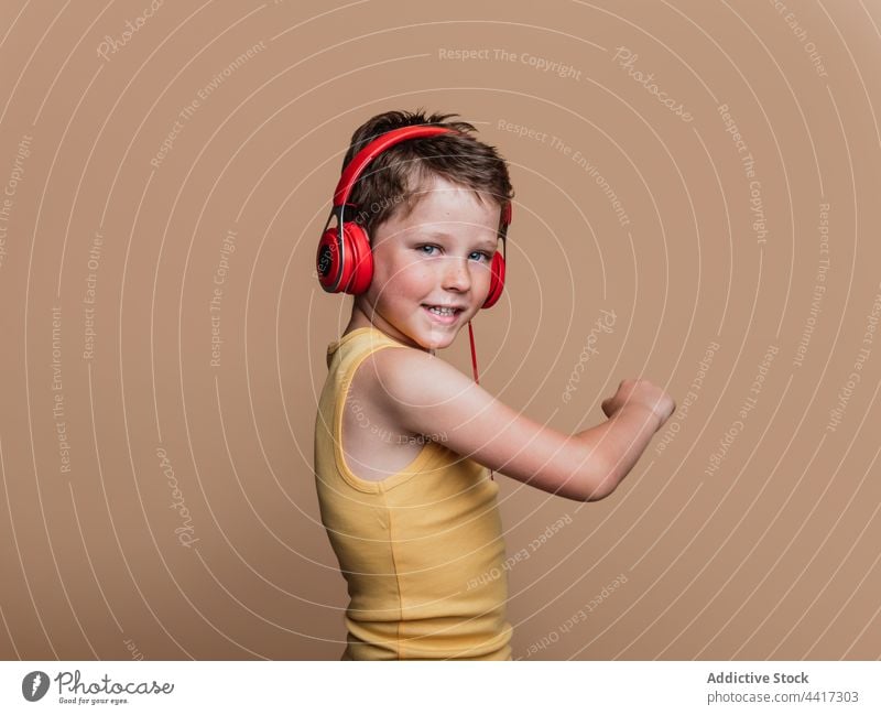 Cheerful child listening to music in headphones song enjoy preteen boy entertain studio kid device gadget sound style cool amusement talent audio childhood