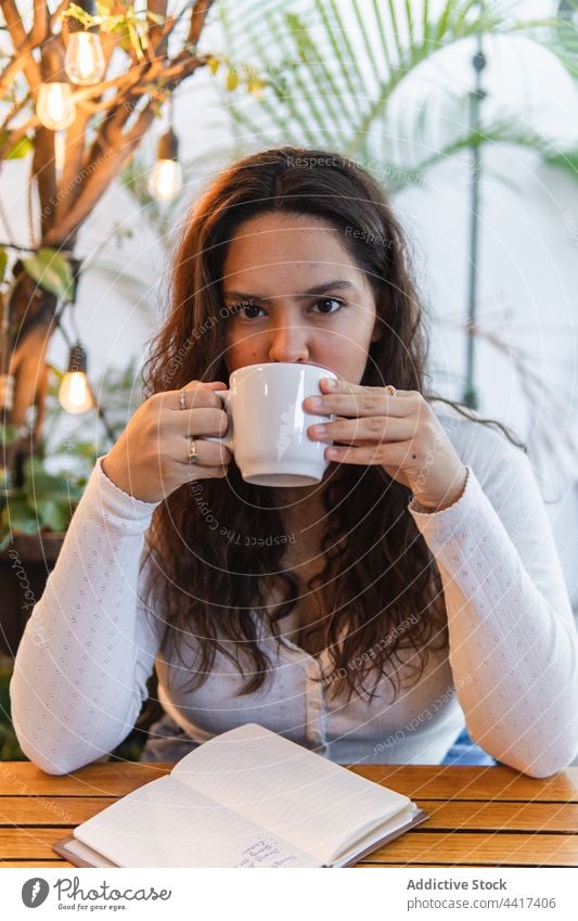 Young woman drinking coffee in cafe cup enjoy rest break female young ethnic latin american beverage aromatic tasty relax lifestyle energy positive pleasure mug