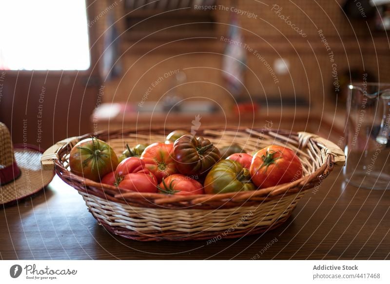 Ripe tomatoes in wicker basket on table harvest ripe pile fresh vegetable rustic kitchen organic edible vitamin raw food heap healthy delicious vegan bunch