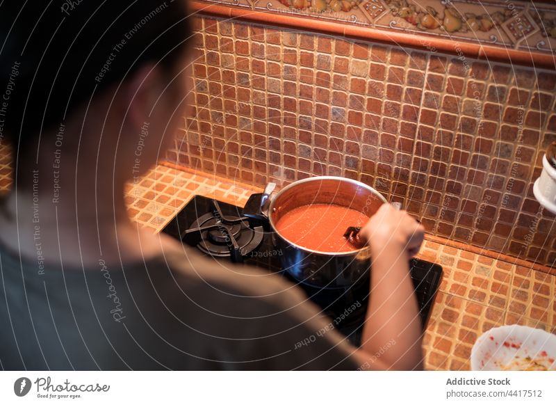 Crop woman preparing marinara sauce from tomatoes in saucepan cook salt add pour stove female prepare culinary recipe kitchen dish cuisine home delicious