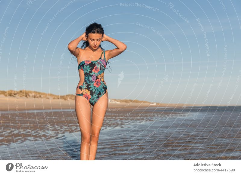 Woman in swimsuit on seashore in summer woman beach vacation enjoy smile holiday cheerful female swimwear summertime sunlight sunny coast wet water positive