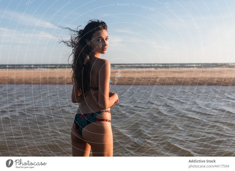 Woman in swimsuit on seashore in summer woman beach vacation enjoy holiday cheerful female swimwear summertime sunlight sunny coast wet water positive idyllic