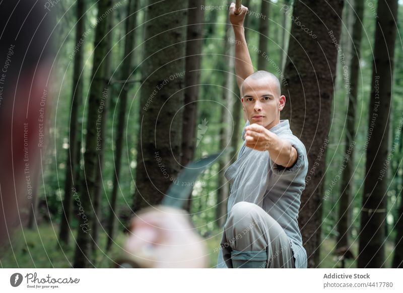 Warrior monks training in forest men warrior kung fu practice opponent stance martial stick sword activity oriental nature energy together fighter balance