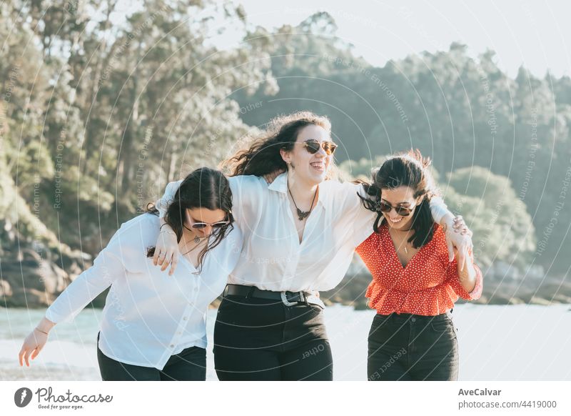 Happy young women laughing and smiling at the beach on a summer day, enjoying vacation, concept of friendship enjoying the outdoor party happiness people group