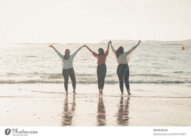 Happy women friends runs at sea beach during a bright day, friends happy relax having fun playing on beach near sea when sunset in evening. friendship party