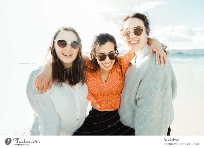 Happy young women laughing and smiling at the beach on a summer day, enjoying vacation, concept of friendship enjoying the outdoor party happiness people group