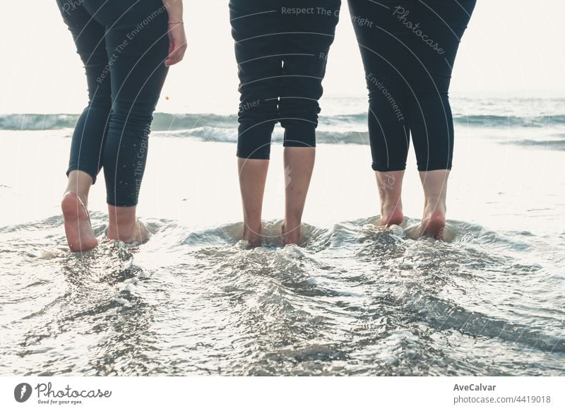 Close up of three women legs on the beach during a sunny day, vacation and relax concept person step teenage sand arena down dusk enjoy ethnic fingers friends