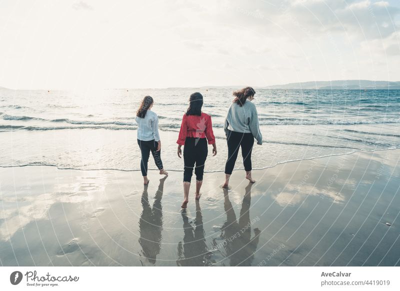 Happy young women laughing and smiling on the beach on a summer day, enjoying the holiday, enjoying the concept of friendship outdoors Friends Friendship Party